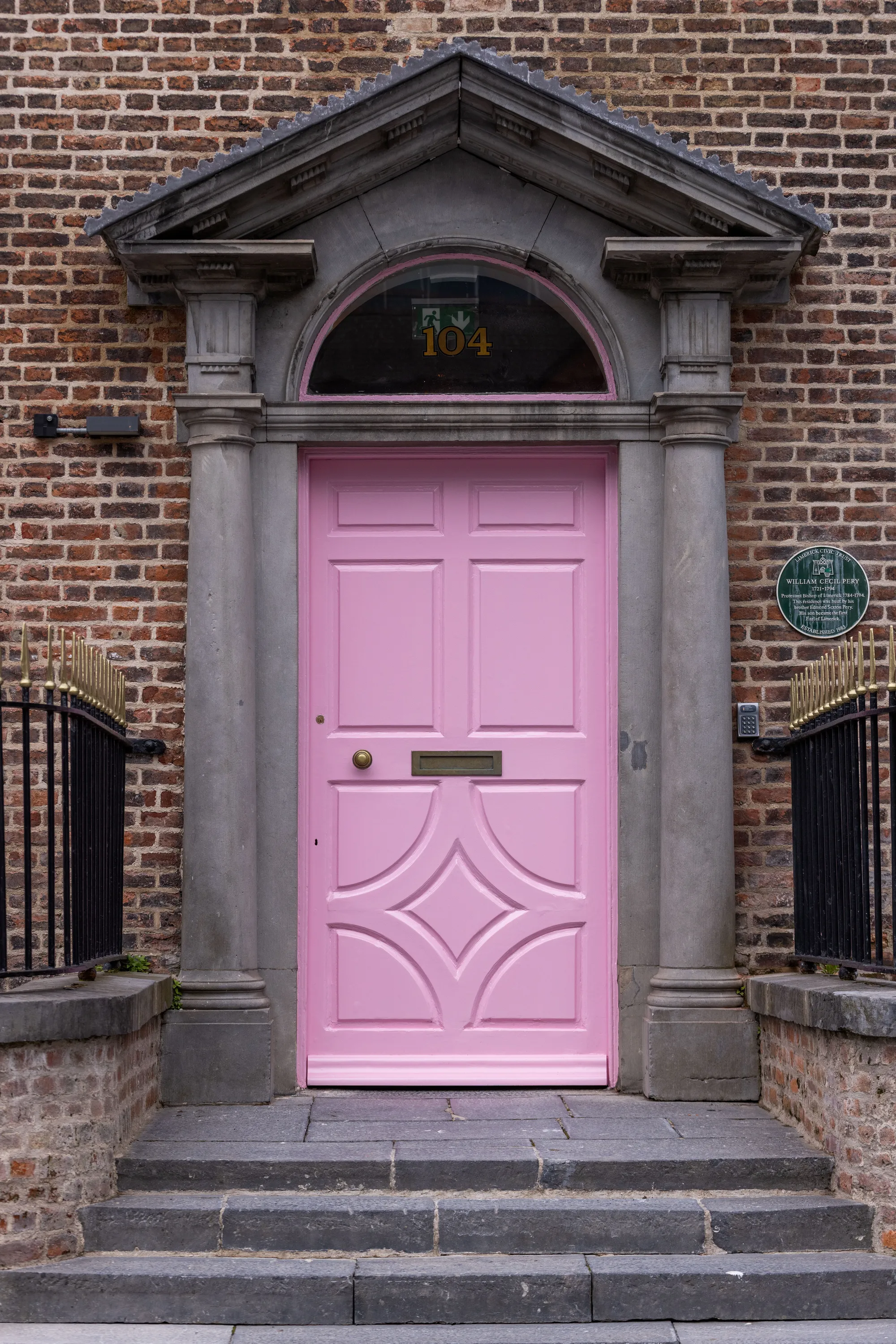 The pink front door and stone steps of The Palace