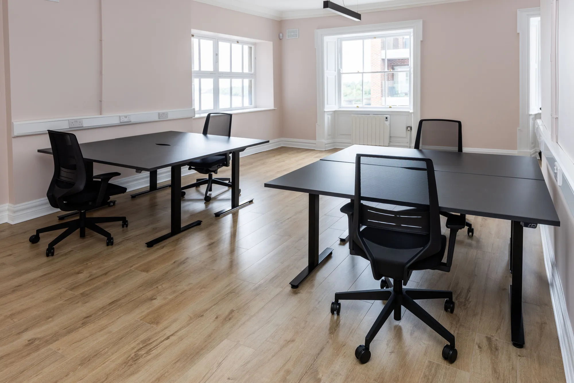 A private office with desk pods by the windows
