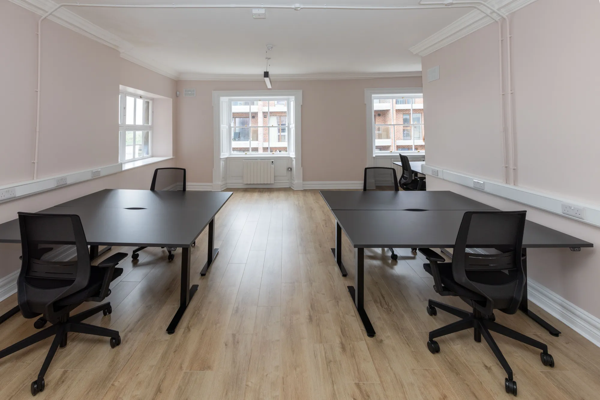 A private office with two desk pods facing the windows