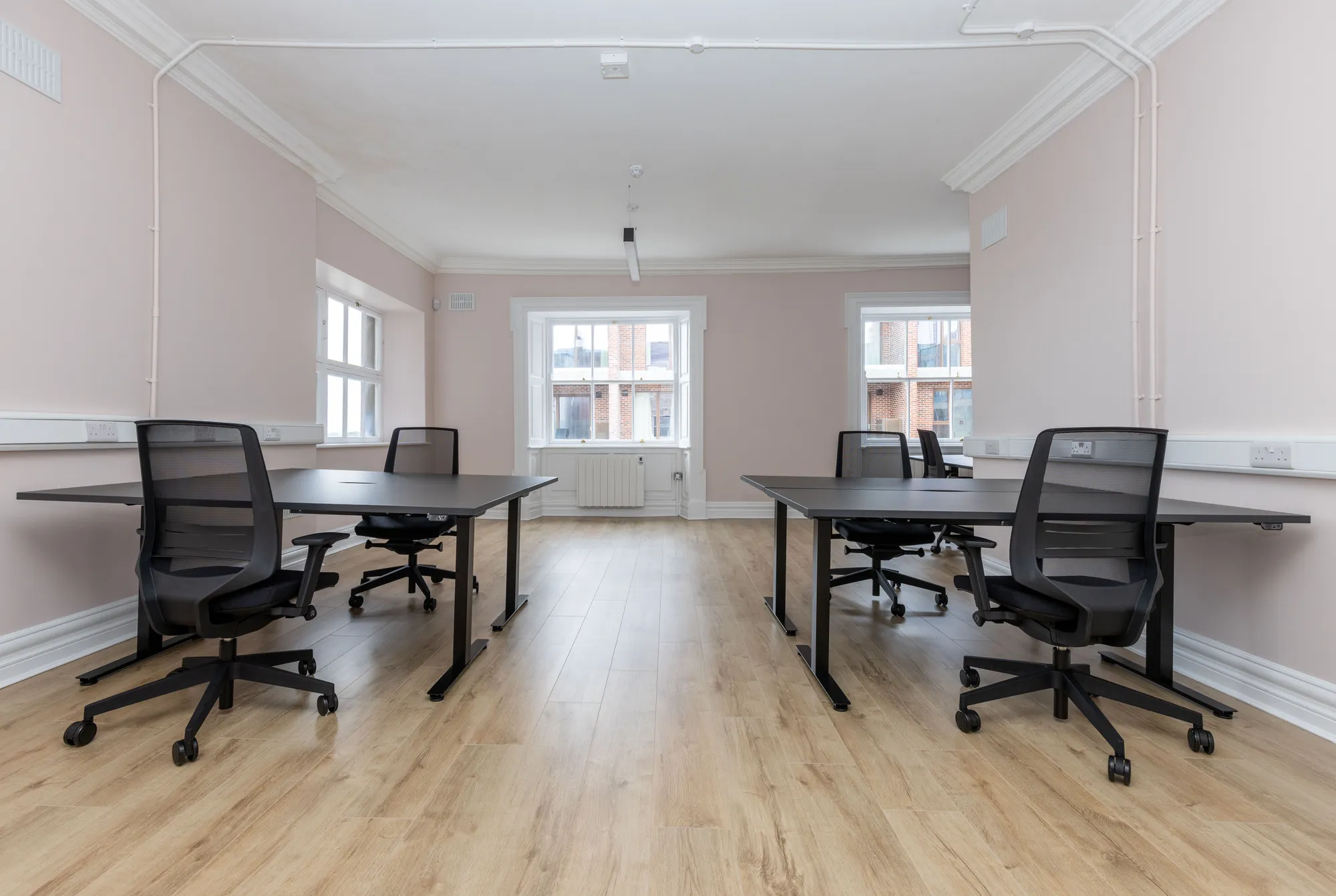 A private office with two desk pods facing the windows