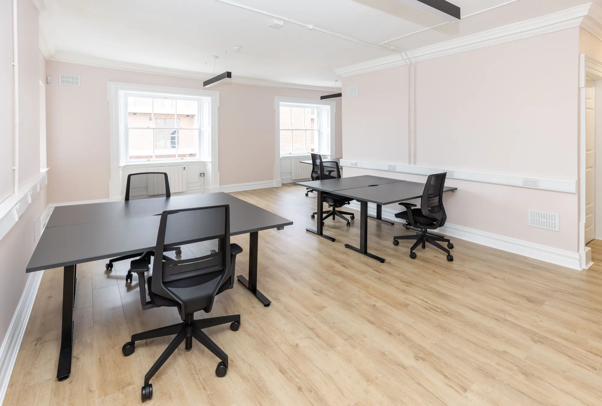 A private office with desks and a sash window