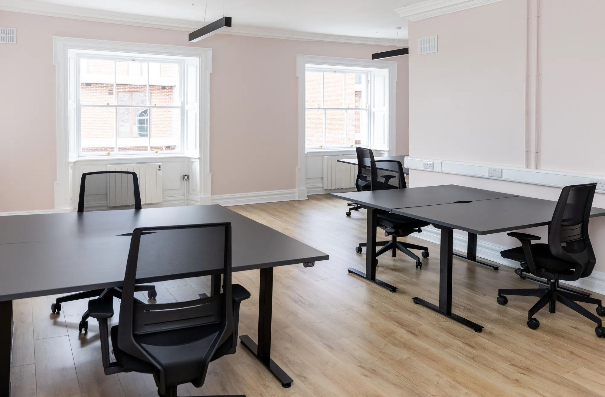A private office with desks and sash windows