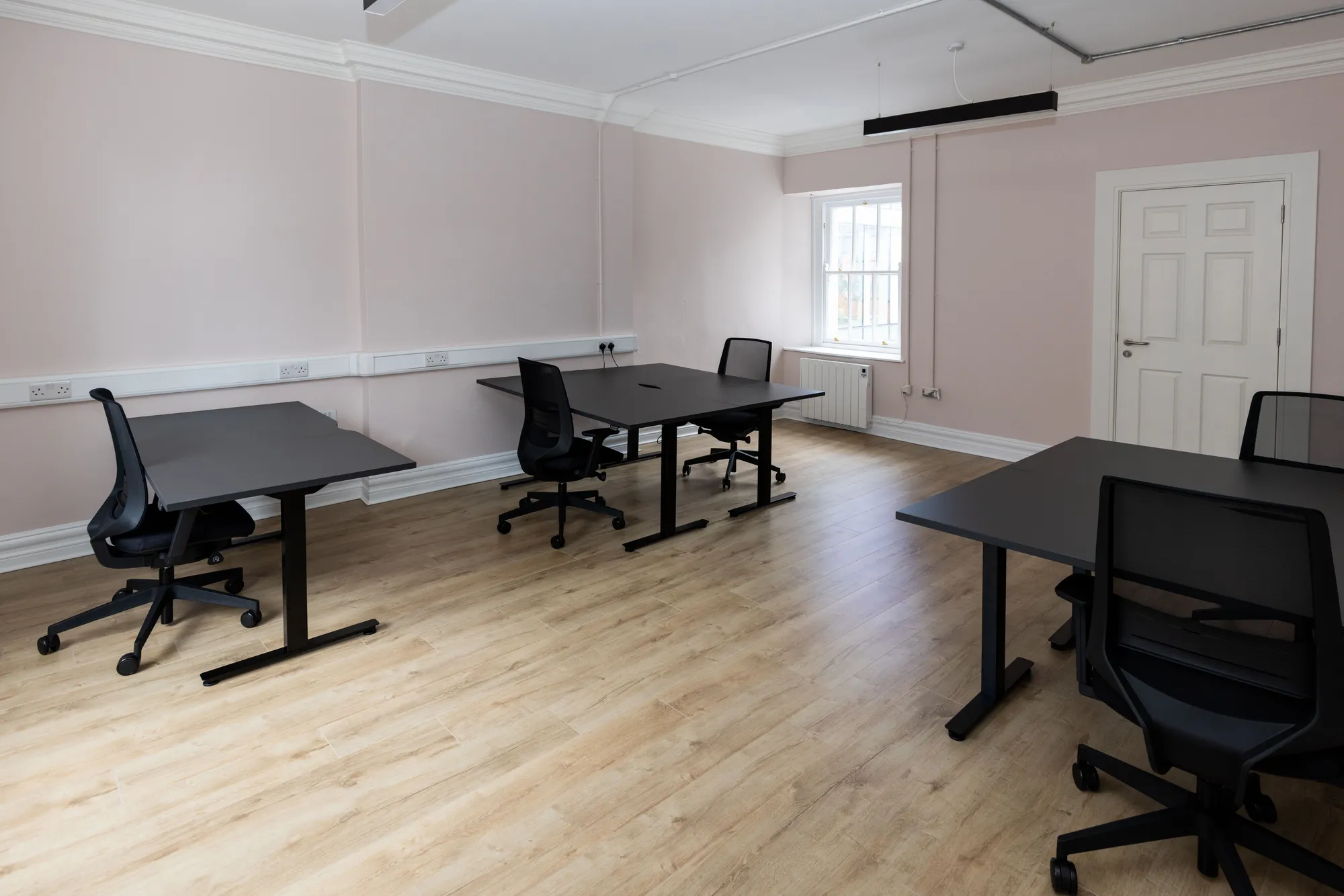 A private office with desks and a panelled Georgian door