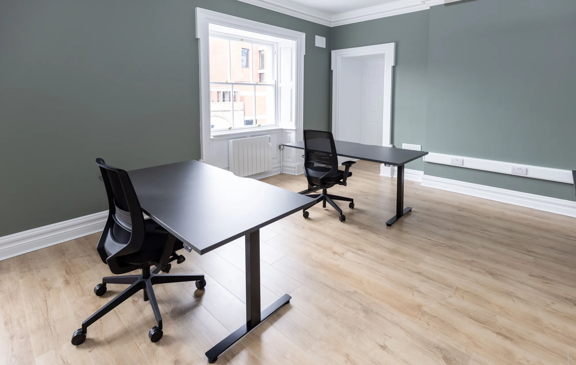 A private office with desks by a Georgian window