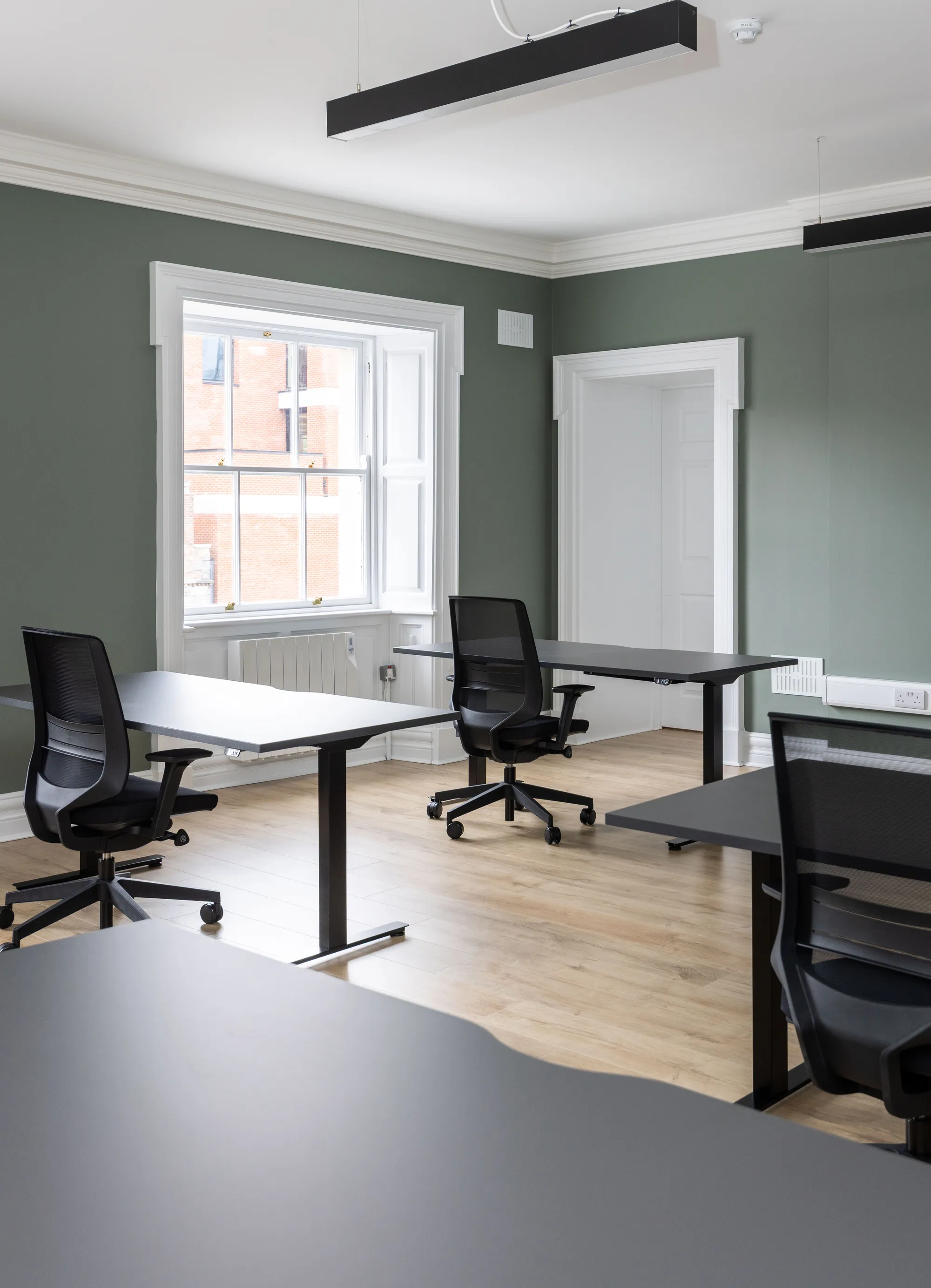 A private office with desks by a sash window