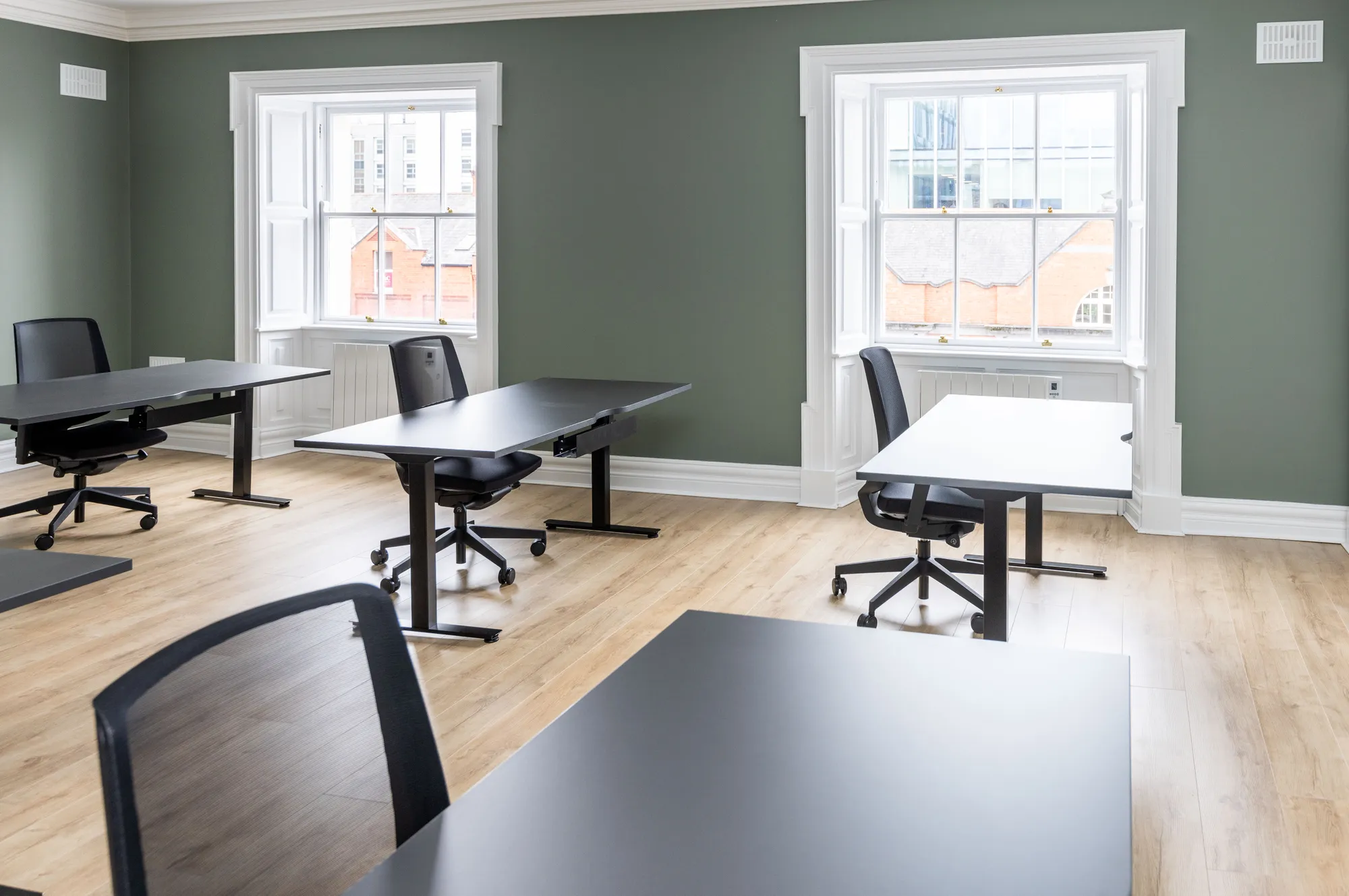 A bright private office with two tall sash windows