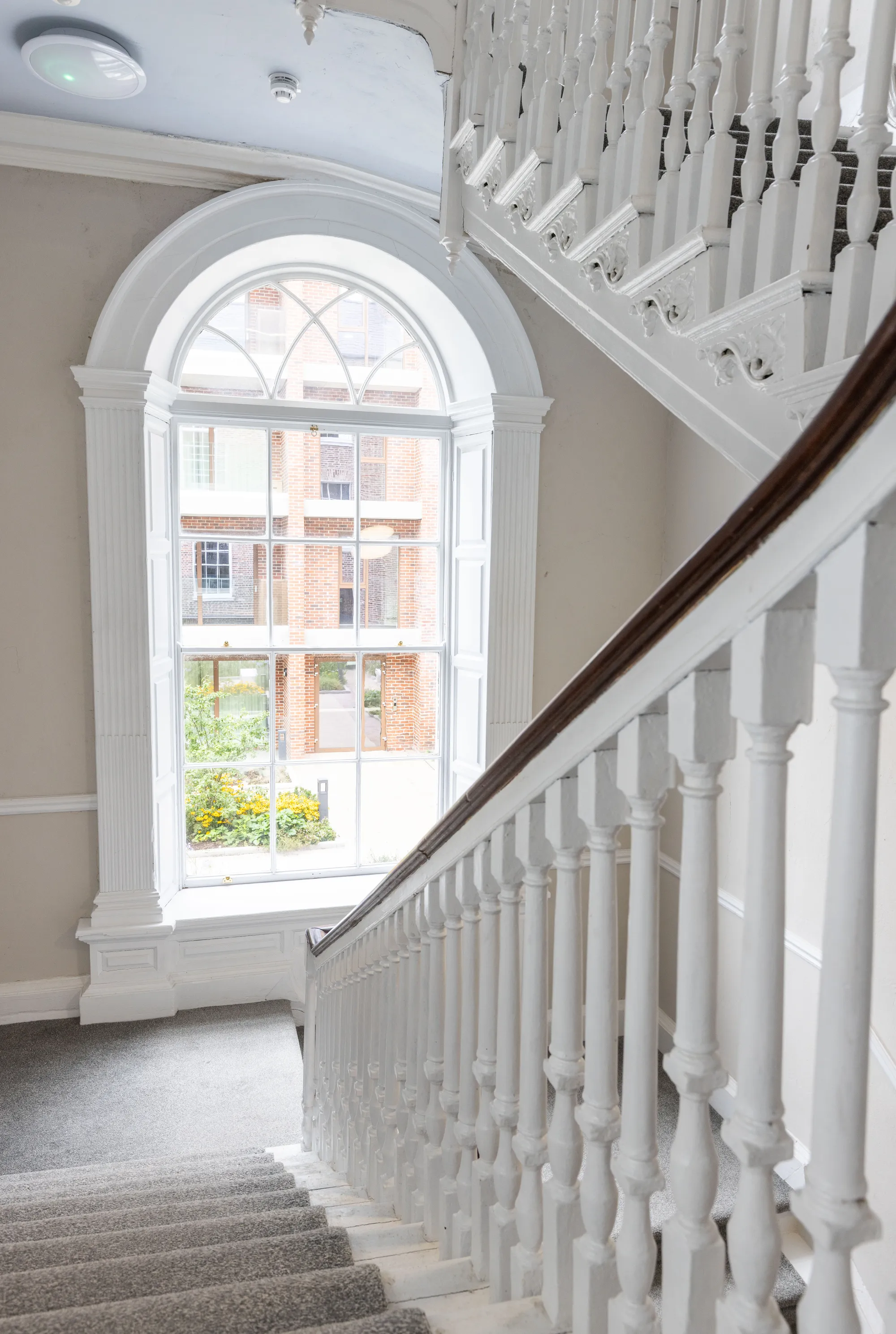 The arched landing window beside the white balustrade